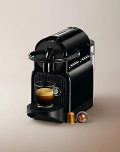 Crni Nespresso aparat za kafu u kapsulama sa staklenom šoljicom espresa i kapsulama – Espresso Guide